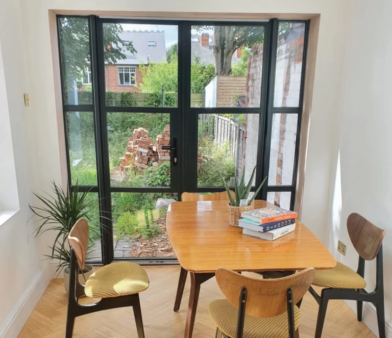 black French aluminium heritage door behind dining table - Integra Window Systems